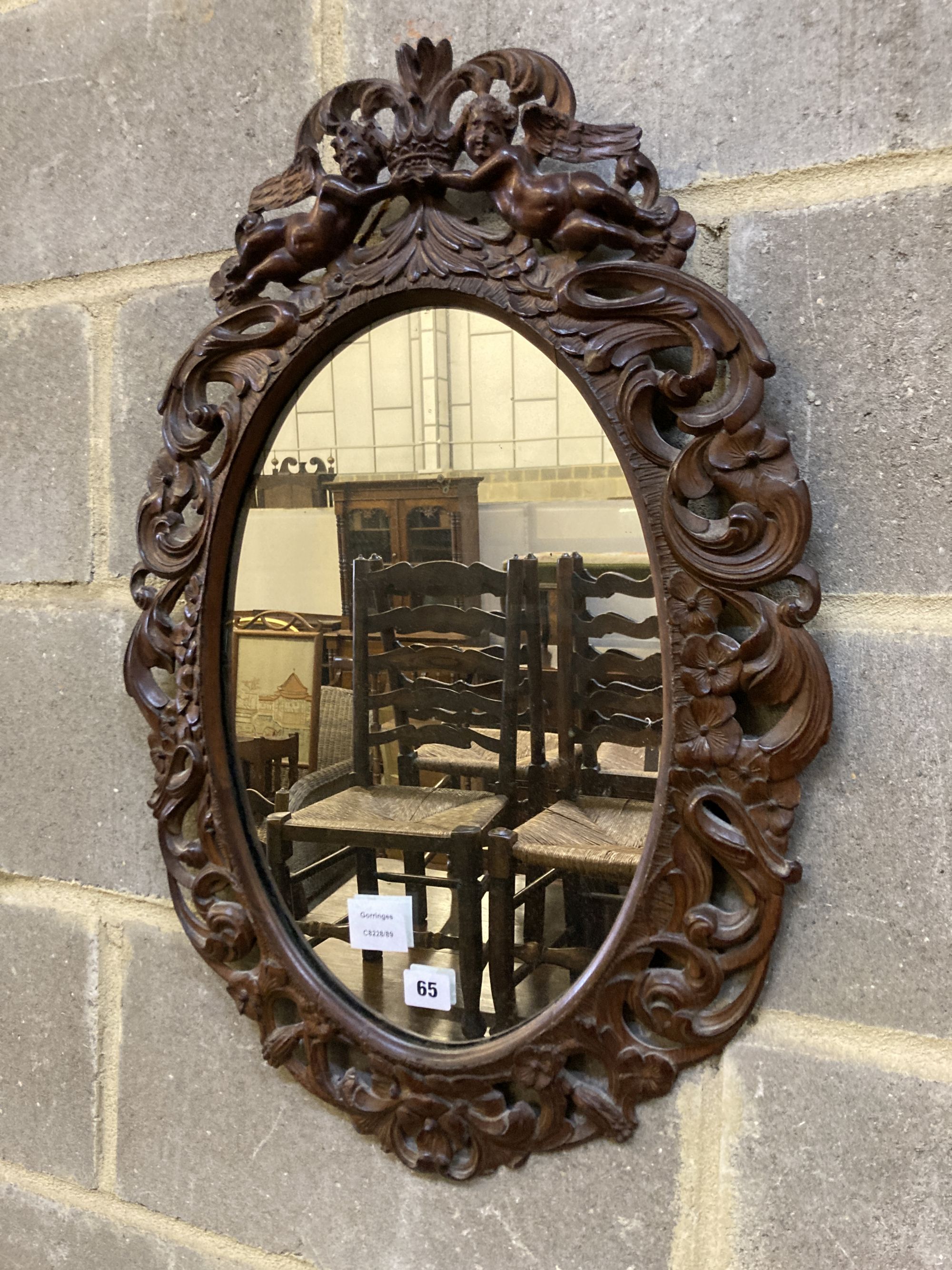 A Carolean style carved walnut oval mirror, width 48cm, height 68cm